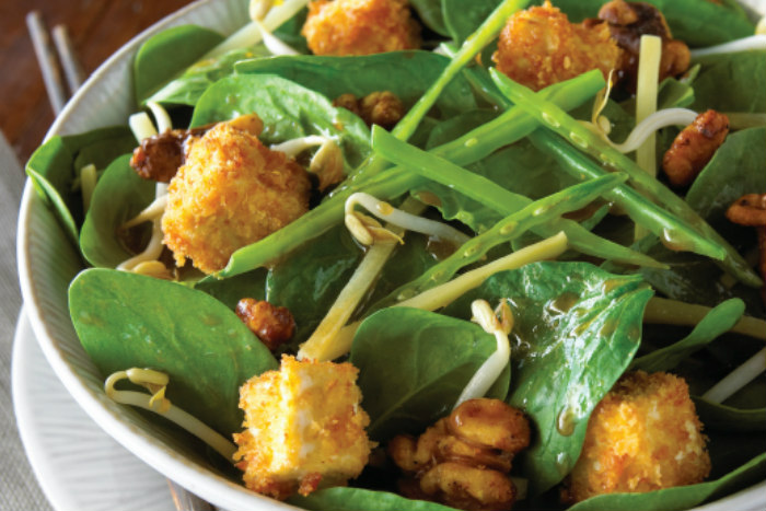 Asian spinach salad in a white bowl
